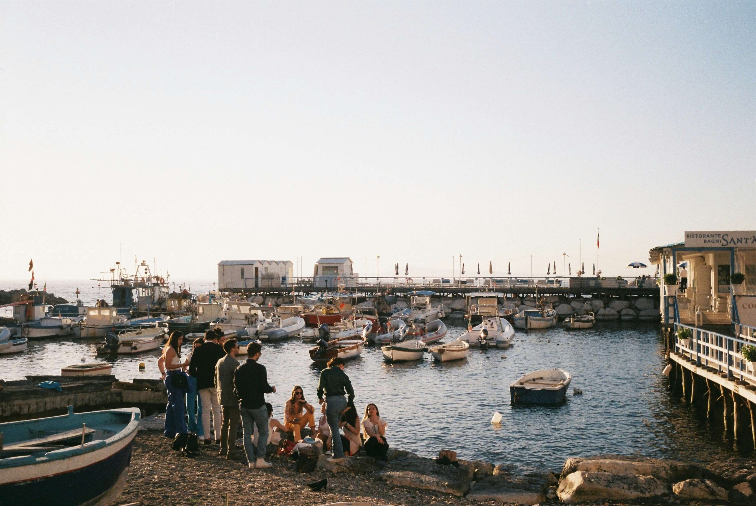 Poche persone, una barca e un mare